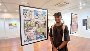 Isaiah Tagilala with one of his mixed-media collages, part of Dancing With The Times, as other works surround him in the Epeli Hau’ofa Art Gallery at the University of the South Pacific in Suva. EXPLORE Fiji photo.