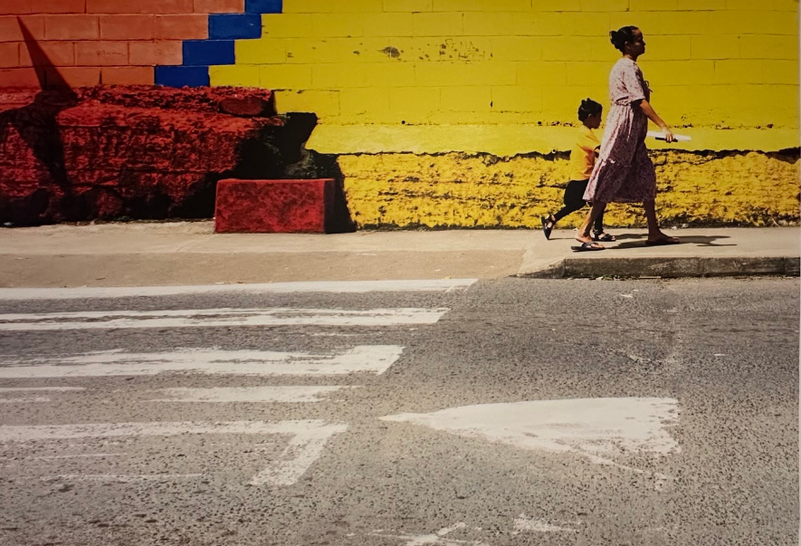 “Lifespan of Life, 2023” by Isaiah Tagilala, showing a mother and child walking the streets with vibrant urban textures behind them. EXPLORE Fiji photo.

