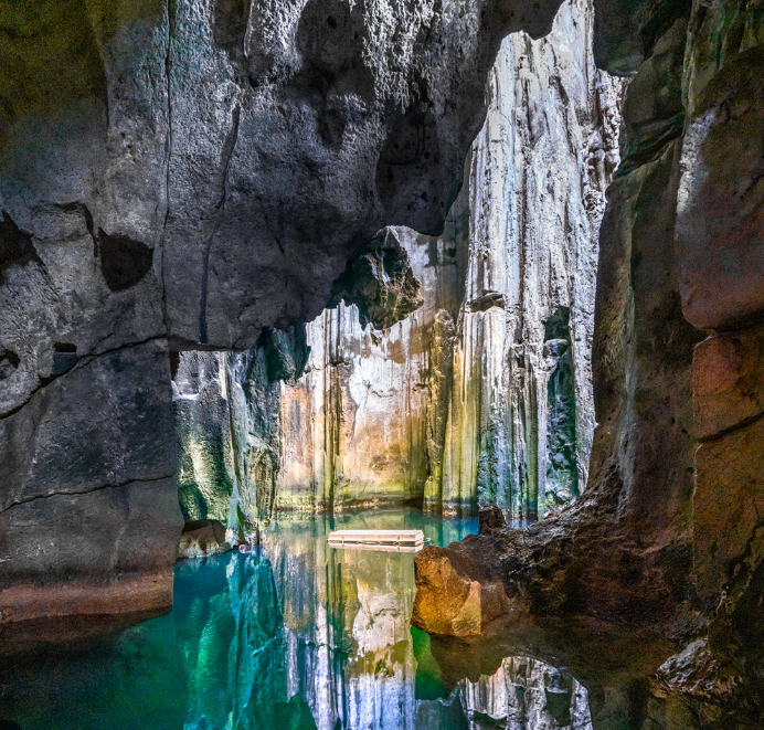 Interior view of Sawa-i-Lau limestone caves in Fiji with turquoise water and sunlight streaming through rock openings. Yasawa Adventures Fiji photo.
