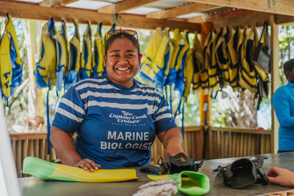 Smiling staff member at Captain Cook Cruises Fiji island counter on Kadavu Lailai.