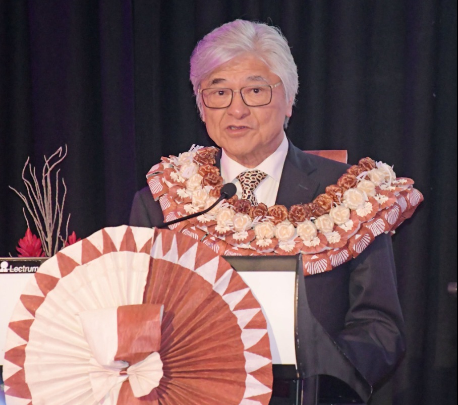 Warwick Hotels and Resorts Chairman Richard Chiu wearing a traditional shell lei while speaking at a podium